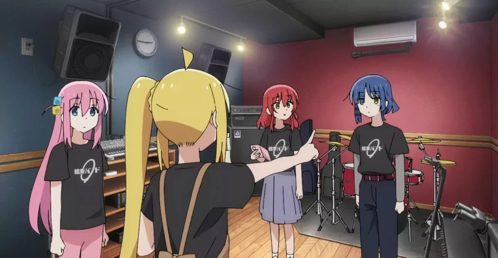 The band members of Bocchi the Rock! gathered in a practice room, preparing for their performance while wearing matching shirts.