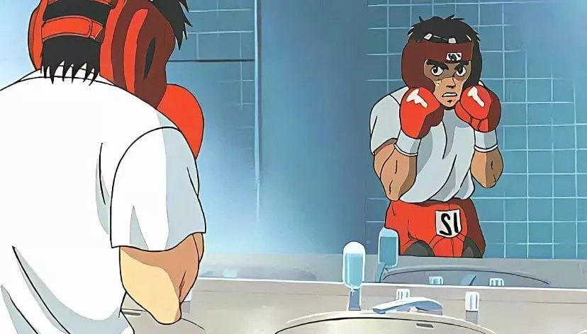 Ippo Makunouchi, the determined boxer from Hajime no Ippo, gazes intensely into a mirror, embodying the spirit of a definitive boxing anime.