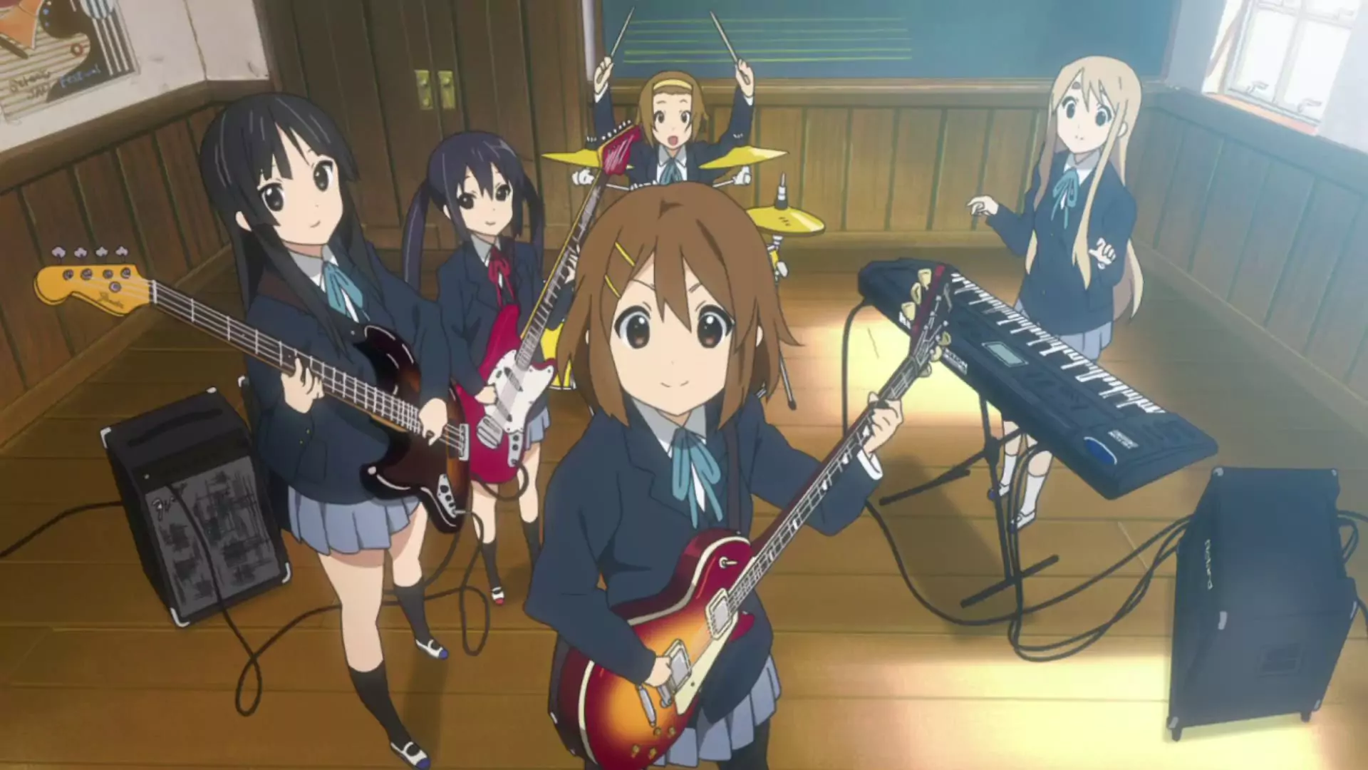 K-On! band members Yui, Mio, Ritsu, Mugi, and Azusa play music together in their school’s music room.
