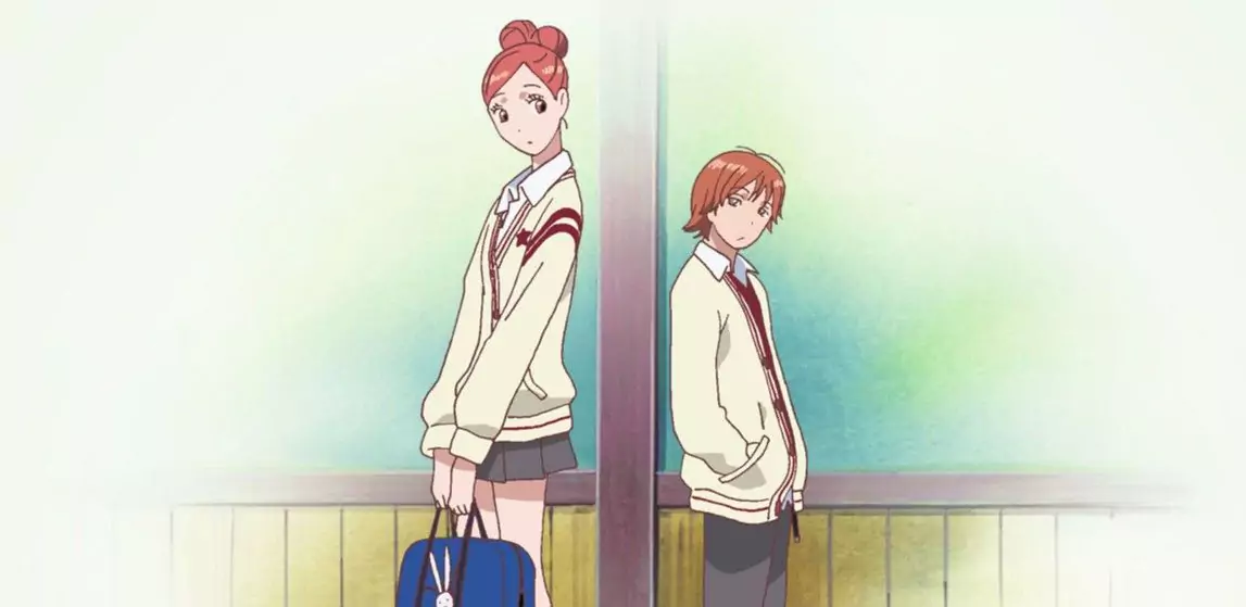 Risa Koizumi standing beside Atsushi Otani in a school hallway in Lovely Complex anime, depicting school life and youthful romance.