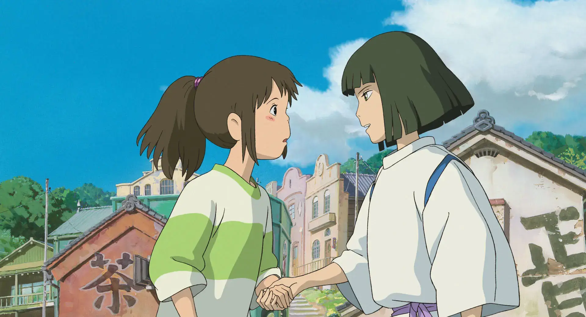 Chihiro and Haku hold hands in an emotional scene from Spirited Away, one of the best anime movies ever made.