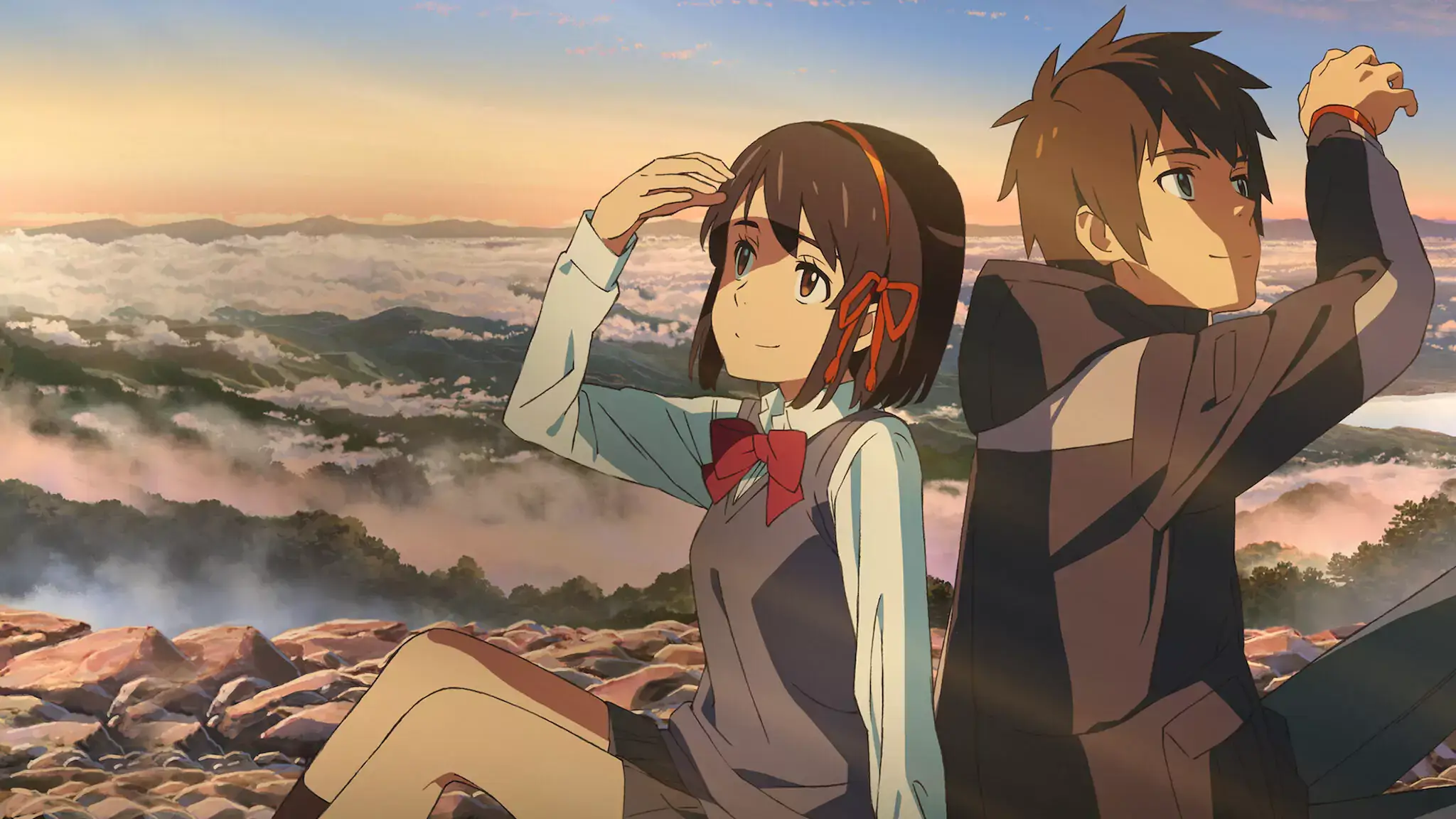 A stunning landscape shot shows Taki and Mitsuha watching a beautiful sunset